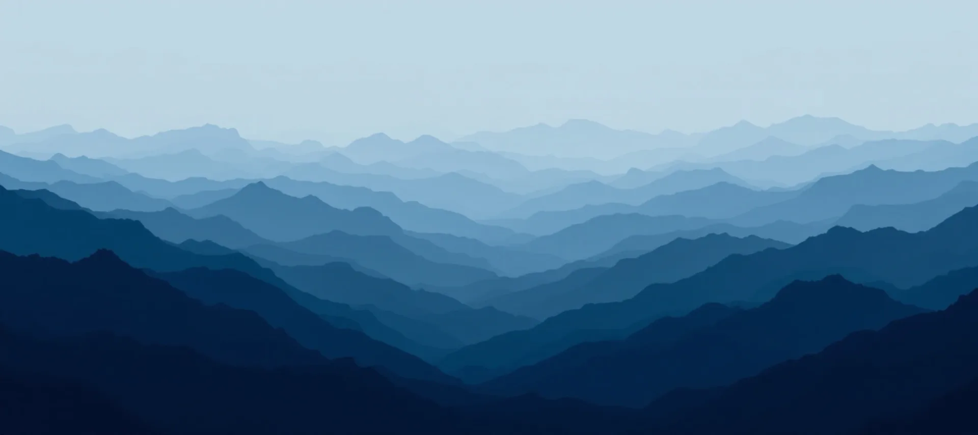 Layered mountain ridgelines receding into haze at dawn